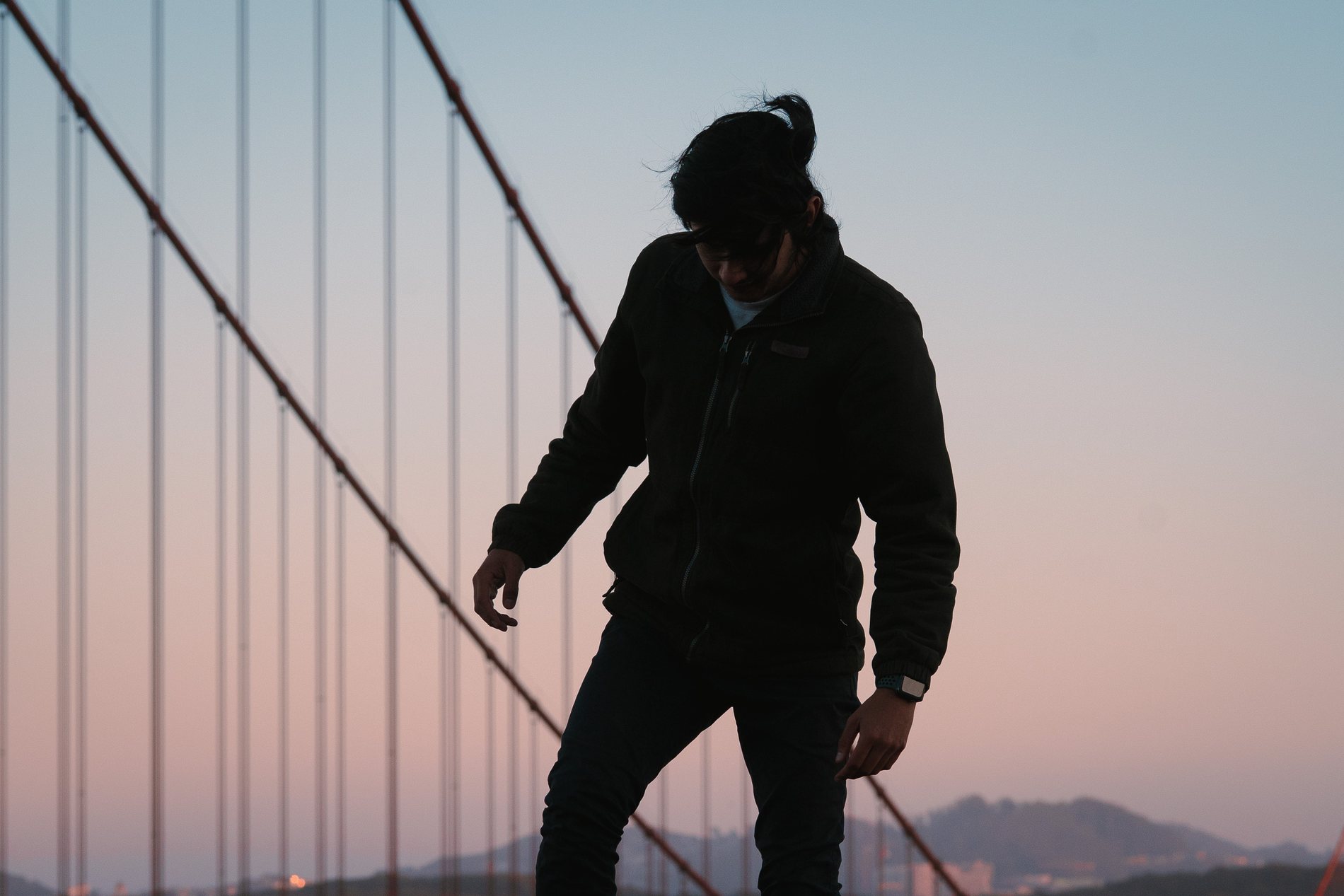 Silhouette against the cables of the Golden Gate Bridge at dusk