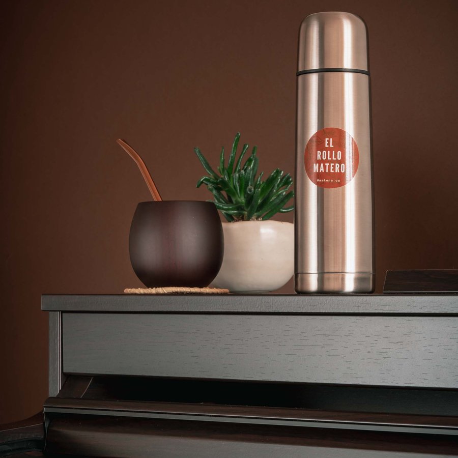 A steel thermos, a mate cup and a plant on a shelf